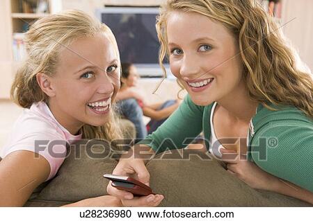 Teenagers Hanging Out In Front Of Television Using Mobile Phones View Large Photo Image Stock Image - Teenagers Hanging Out In Front Of Television Using Mobile Phones . Fotosearch
