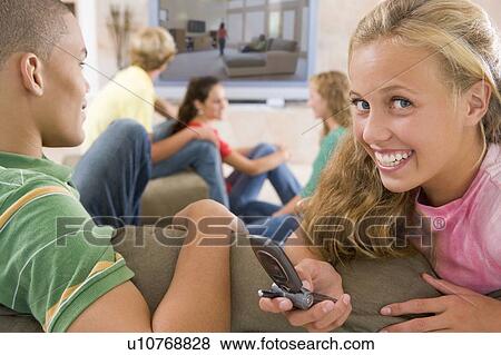 Teenagers Hanging Out In Front Of Television Using Mobile Phones View Large Photo Image Stock Photo - Teenagers Hanging Out In Front Of Television Using Mobile Phones . Fotosearch