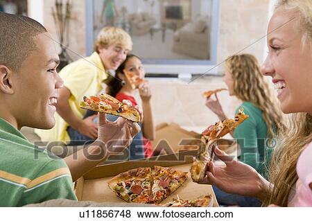 Teenagers Hanging Out In Front Of Television Eating Pizza View Large Photo Image Stock Photo - Teenagers Hanging Out In Front Of Television Eating Pizza . Fotosearch