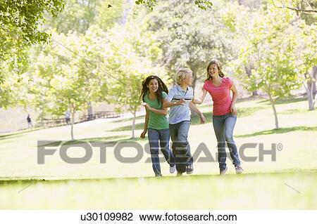 Stock Image - Teenagers Running Through Park. Fotosearch
