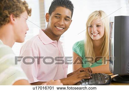 Stock Image - Teenagers Using Desktop Computer Together. Fotosearch