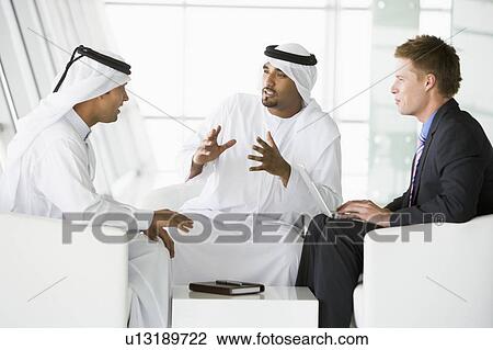 Three businessmen indoors with laptop talking (high key/selective focus) View Large Photo Image Stock Image - Three businessmen indoors with laptop talking (high key/selective focus). Fotosearch