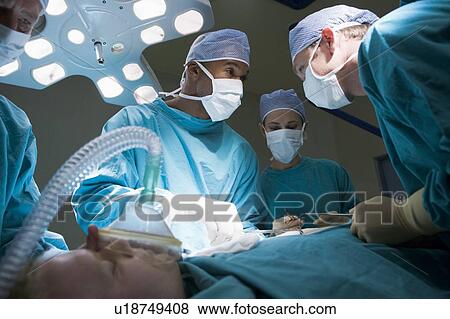 Stock Photo - Three Surgeons Operating On A Patient. Fotosearch