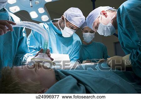 Stock Photo - Three Surgeons Operating On A Patient. Fotosearch