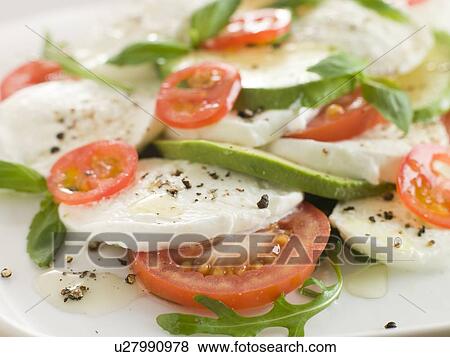 Stock Photo - Tomato Avocado and Mozzarella Salad with Olive Oil and Black Pepper. Fotosearch