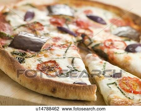 Stock Image - Tomato Mozzarella Aubergine and Basil Pizza. Fotosearch