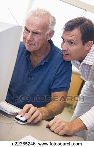 Two men at computer looking at monitor (high key) View Large Photo Image Stock Photograph - Two men at computer looking at monitor (high key). Fotosearch