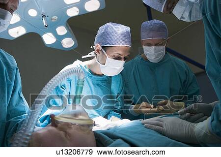 Stock Photo - Two Surgeons Operating On A Patient. Fotosearch