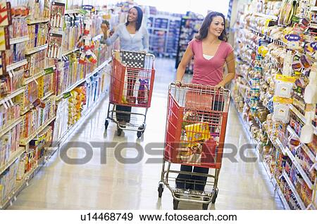 Stock Photo - Two women shopping at a grocery store. Fotosearch