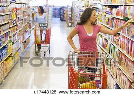 Two women shopping at a grocery store View Large Photo Image Stock Photo - Two women shopping at a grocery store. Fotosearch