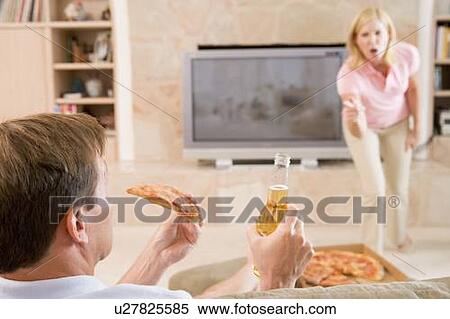 Stock Photography - Wife Telling Husband Off For Drinking Beer And Eating Pizza. Fotosearch