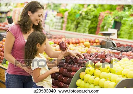 Woman and daughter shopping for apples at a grocery store View Large Photo Image Stock Image - Woman and daughter shopping for apples at a grocery store. Fotosearch