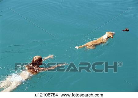 Woman and dog outdoors swimming in lake View Large Photo Image Picture - Woman and dog outdoors swimming in lake. Fotosearch