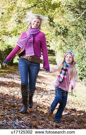 Woman and young girl walking on path outdoors smiling (selective focus) View Large Photo Image Stock Image - Woman and young girl walking on path outdoors smiling (selective focus). Fotosearch