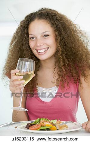 Stock Photography - Woman Eating meal, mealtime With A Glass Of Wine . Fotosearch