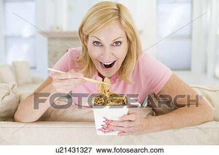Stock Photo - Woman Eating meal, mealtime With Chopsticks . Fotosearch