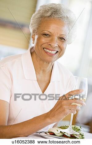 Stock Photo - Woman Enjoying meal, mealtime With A Glass Of Wine. Fotosearch