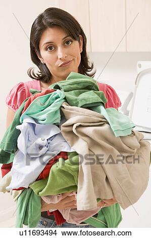 Picture - Woman Holding Pile Of Laundry. Fotosearch