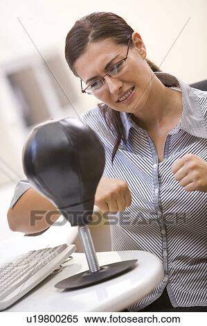Woman in computer room using small punching bag for stress relief View Large Photo Image Stock Photography - Woman in computer room using small punching bag for stress relief. Fotosearch