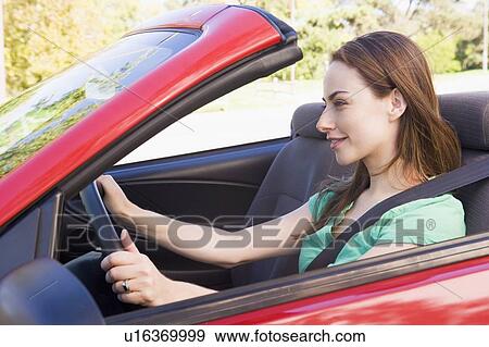 Stock Photo - Woman in convertible car smiling. Fotosearch