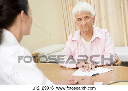 Stock Photograph - Woman in doctor's office frowning. Fotosearch