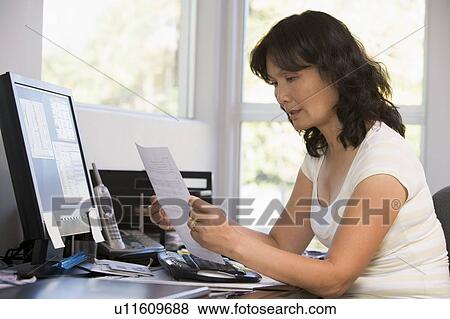 Woman in home office with computer and paperwork View Large Photo Image Stock Photo - Woman in home office with computer and paperwork. Fotosearch
