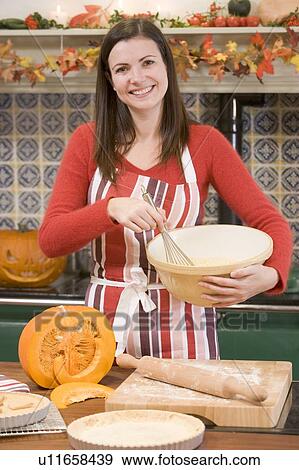 Woman in kitchen making Halloween treats and smiling View Large Photo Image Stock Photo - Woman in kitchen making Halloween treats and smiling. Fotosearch