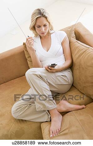 Woman in living room using personal digital assistant smiling View Large Photo Image Stock Photo - Woman in living room using personal digital assistant smiling. Fotosearch