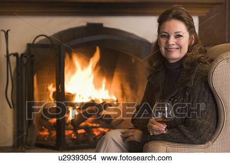 Woman in living room with drink smiling View Large Photo Image Picture - Woman in living room with drink smiling. Fotosearch