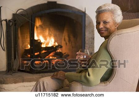 Woman in living room with drink smiling View Large Photo Image Stock Image - Woman in living room with drink smiling. Fotosearch