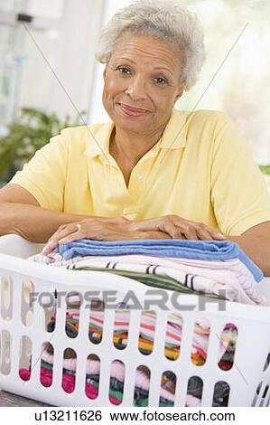 Stock Photograph - Woman Leaning On Washing Basket . Fotosearch