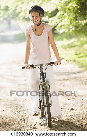 Woman on bicycle smiling View Large Photo Image Stock Image - Woman on bicycle smiling. Fotosearch