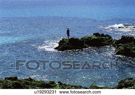 Woman outdoors standing on large rocks Oceanside (far away/silhouette) View Large Photo Image Stock Image - Woman outdoors standing on large rocks Oceanside (far away/silhouette). Fotosearch