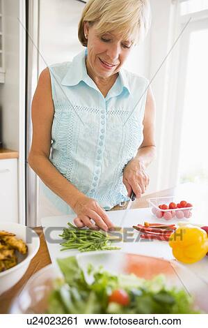 Stock Image - Woman Preparing meal, mealtime . Fotosearch