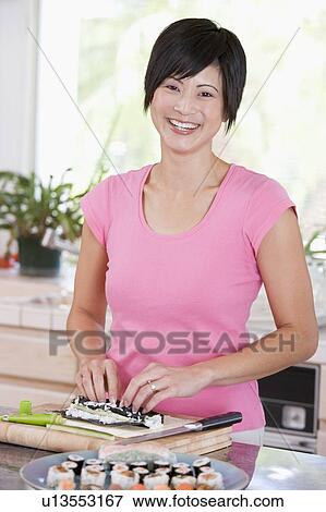Stock Photo - Woman Preparing Sushi. Fotosearch