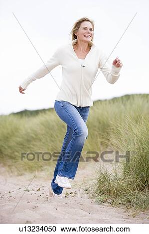 Woman running at beach smiling View Large Photo Image Stock Image - Woman running at beach smiling. Fotosearch