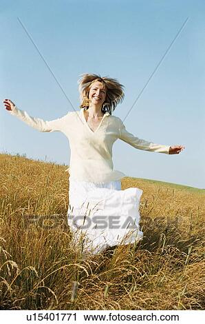 Stock Image - Woman running outdoors smiling. Fotosearch