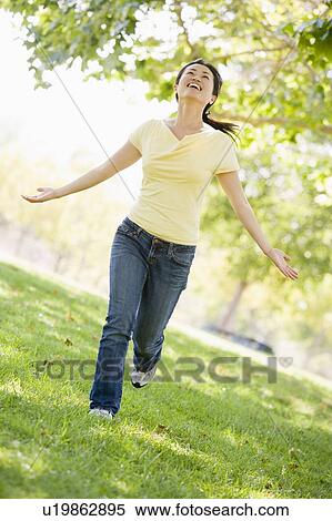 Woman running outdoors smiling View Large Photo Image Stock Photography - Woman running outdoors smiling. Fotosearch