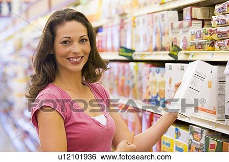 Woman shopping at a grocery store View Large Photo Image Stock Photograph - Woman shopping at a grocery store. Fotosearch