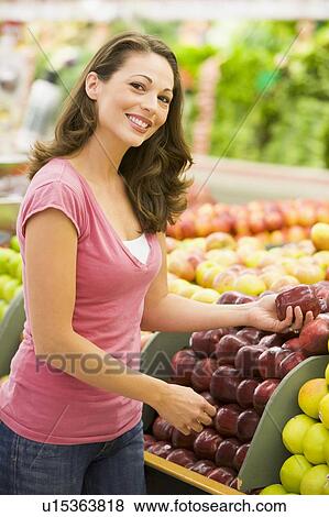 Woman shopping for apples at a grocery store View Large Photo Image Stock Photo - Woman shopping for apples at a grocery store. Fotosearch