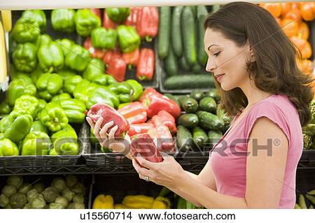 Woman shopping for bell peppers at a grocery store View Large Photo Image Picture - Woman shopping for bell peppers at a grocery store. Fotosearch