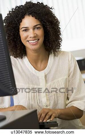 Woman sitting at a computer terminal typing (high key) View Large Photo Image Stock Photography - Woman sitting at a computer terminal typing (high key). Fotosearch