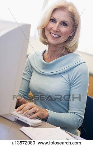 Woman sitting at computer typing (high key) View Large Photo Image Stock Image - Woman sitting at computer typing (high key). Fotosearch