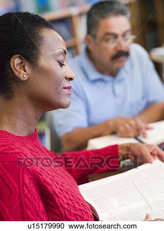 Woman sitting near man in library with books and notepads (selective focus) View Large Photo Image Stock Image - Woman sitting near man in library with books and notepads (selective focus). Fotosearch