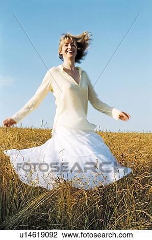 Stock Image - Woman spinning outdoors smiling. Fotosearch