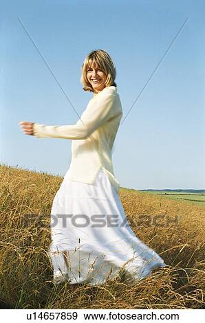 Stock Photo - Woman spinning outdoors smiling. Fotosearch