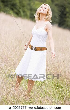 Woman standing outdoors smiling View Large Photo Image Stock Photo - Woman standing outdoors smiling. Fotosearch