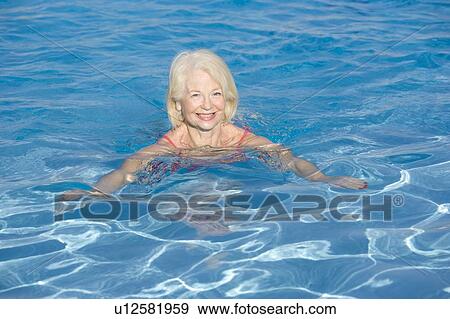Woman swimming in outdoor pool smiling View Large Photo Image Stock Photo - Woman swimming in outdoor pool smiling. Fotosearch