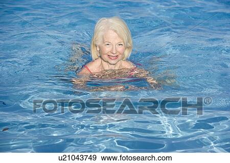 Woman swimming in outdoor pool smiling View Large Photo Image Stock Photo - Woman swimming in outdoor pool smiling. Fotosearch