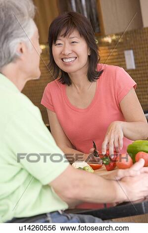 Woman Talking To Husband While Chopping Vegetables View Large Photo Image Stock Photograph - Woman Talking To Husband While Chopping Vegetables. Fotosearch